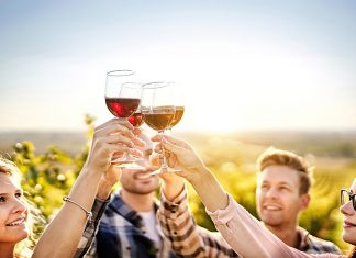 Michigan Wineries Win Top Honors in National & International Competitions Happy people enjoying harvest time together at farmhouse winery countryside