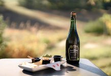 A bottle of Mawby's Safe Sex NA Brut Rose with a plate of snacks.